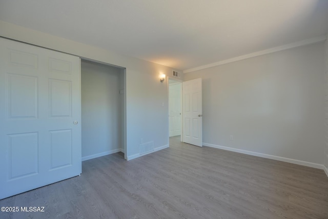 unfurnished bedroom featuring a closet and light hardwood / wood-style floors