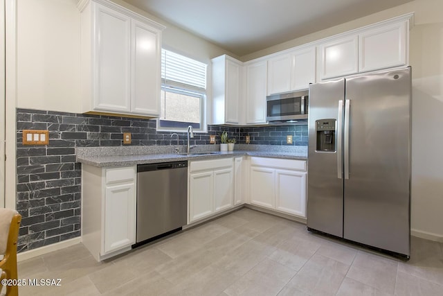 kitchen featuring sink, white cabinets, light stone countertops, and appliances with stainless steel finishes