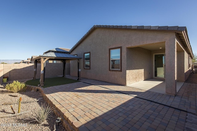 back of property featuring a patio area and a gazebo