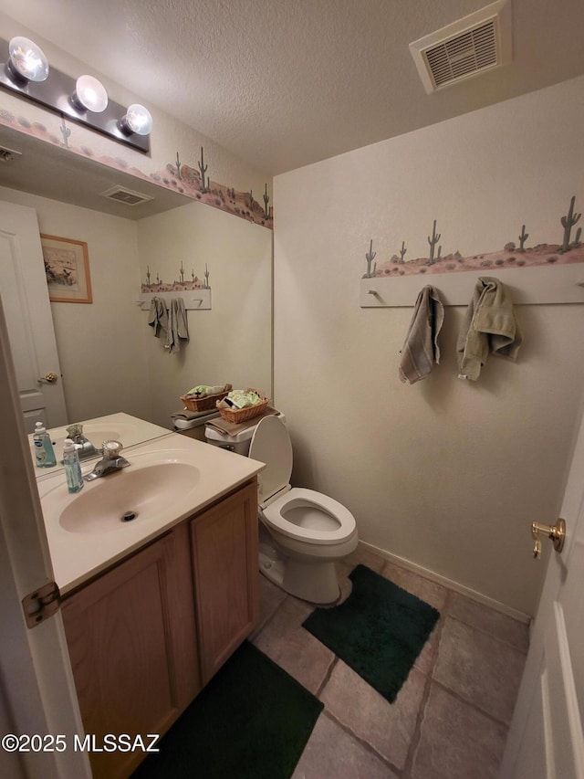 bathroom featuring tile patterned flooring, a textured ceiling, vanity, and toilet