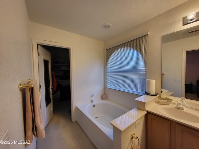 bathroom with a washtub and vanity