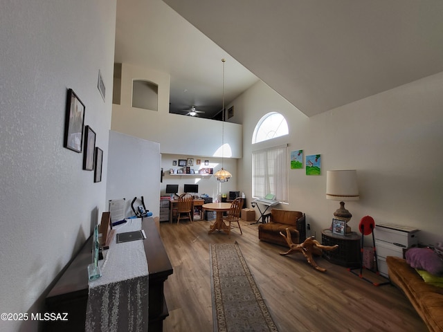 interior space with hardwood / wood-style floors, high vaulted ceiling, and ceiling fan