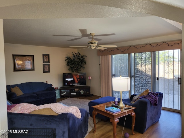 living room with a textured ceiling, hardwood / wood-style flooring, and ceiling fan