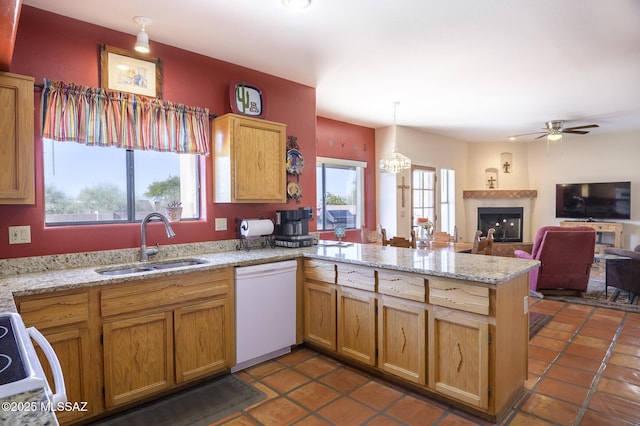 kitchen with sink, decorative light fixtures, kitchen peninsula, white appliances, and light stone countertops