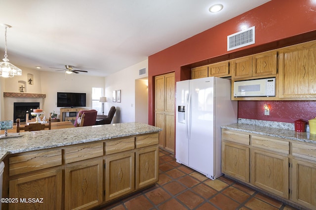 kitchen featuring pendant lighting, dark tile patterned floors, ceiling fan, light stone counters, and white appliances