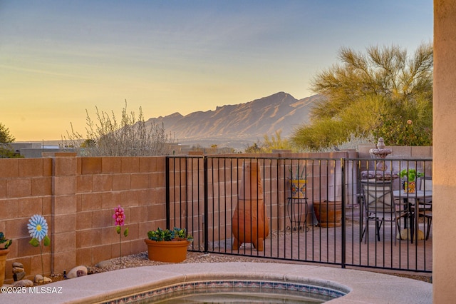 gate at dusk featuring a mountain view