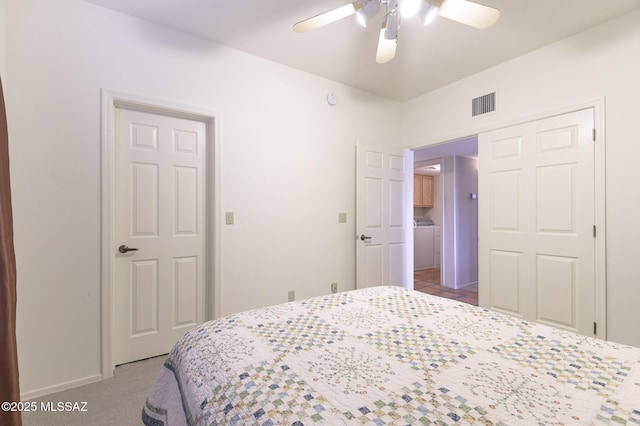 carpeted bedroom featuring ceiling fan, washer / dryer, and a closet