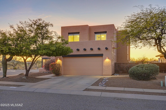 pueblo-style house featuring a garage