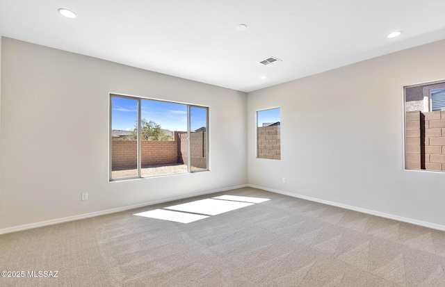 spare room with baseboards and carpet floors