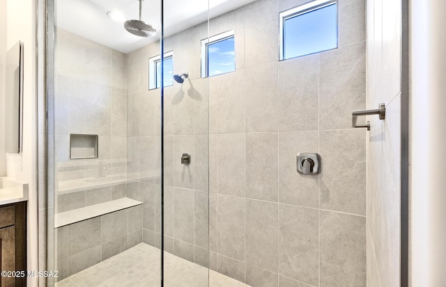bathroom featuring tiled shower and vanity