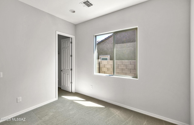 empty room with visible vents, baseboards, and carpet flooring