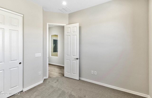 unfurnished bedroom with baseboards, carpet, and visible vents