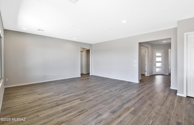 empty room with recessed lighting, baseboards, and wood finished floors