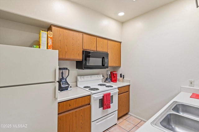 kitchen featuring sink, white appliances, and light tile patterned flooring