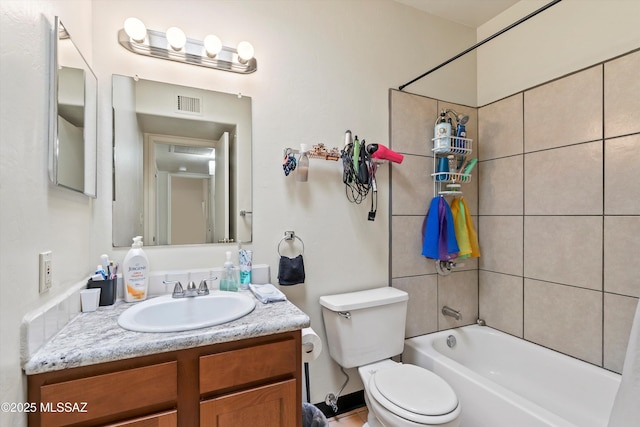 full bathroom with tiled shower / bath combo, vanity, and toilet