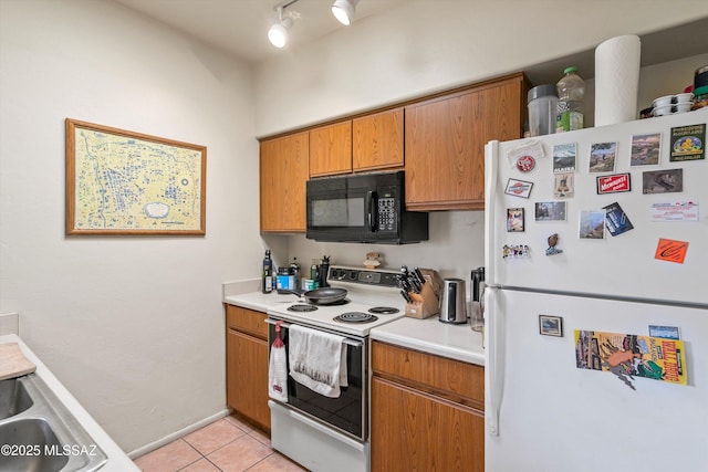 kitchen with white appliances, light tile patterned floors, and sink