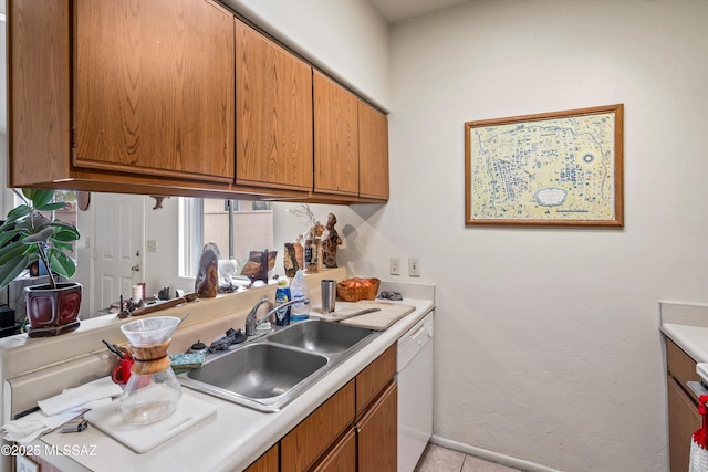 kitchen featuring sink, white dishwasher, and light tile patterned floors