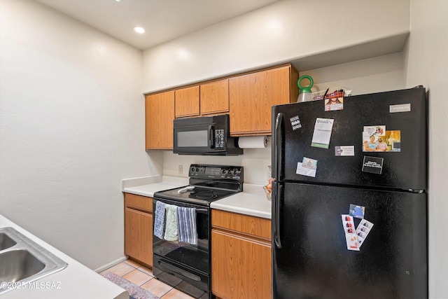 kitchen featuring sink, light tile patterned floors, and black appliances