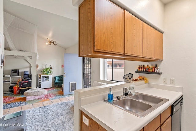 kitchen featuring lofted ceiling, stainless steel dishwasher, light tile patterned flooring, and sink