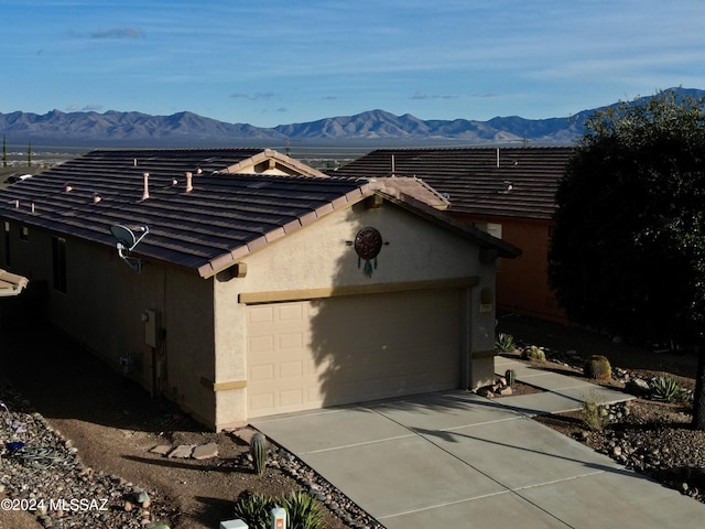 view of side of property with a mountain view and a garage