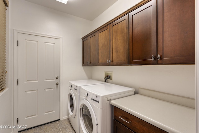 laundry area featuring washer and clothes dryer, cabinets, and light tile patterned floors