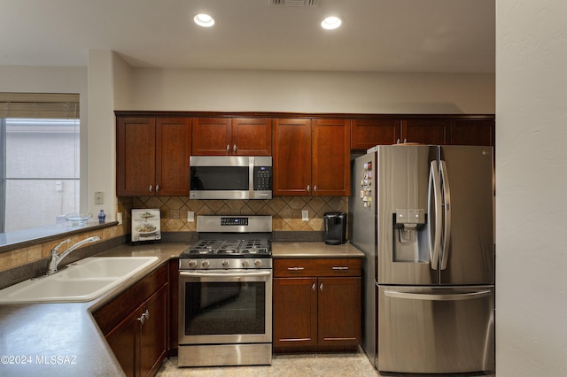 kitchen featuring backsplash, stainless steel appliances, and sink