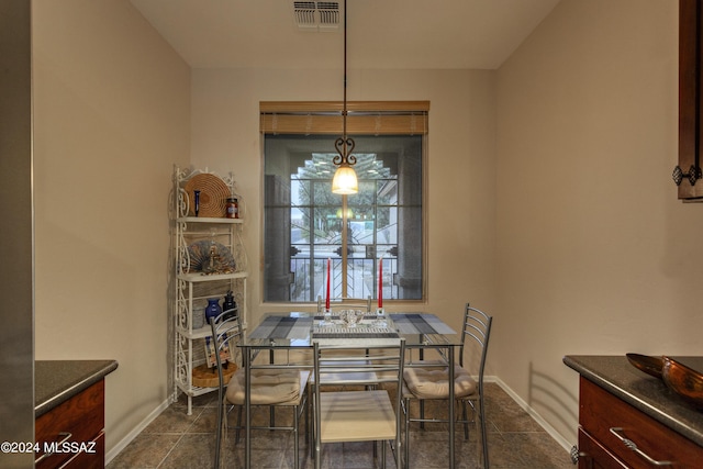 dining space featuring dark tile patterned flooring