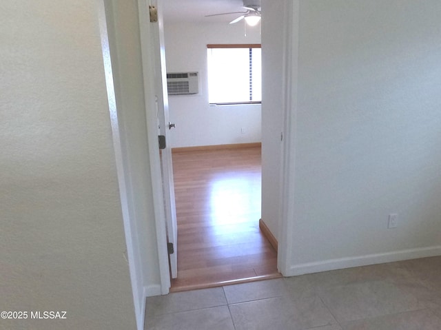 hallway with a wall mounted AC and light tile patterned flooring