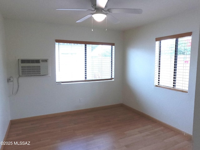 spare room with a wall mounted air conditioner, ceiling fan, and wood-type flooring