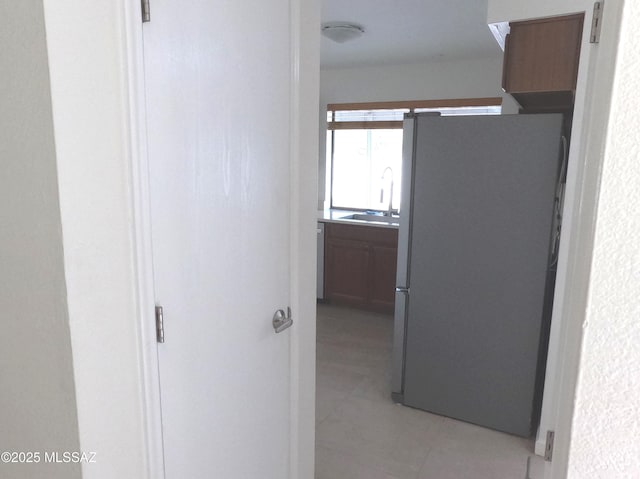 corridor with light tile patterned flooring and sink