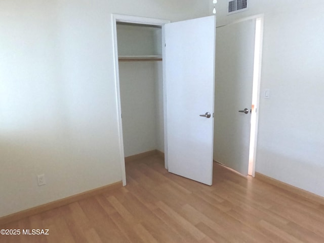 unfurnished bedroom featuring a closet and light hardwood / wood-style floors