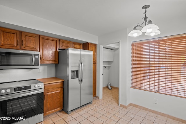 kitchen featuring a chandelier, hanging light fixtures, light tile patterned floors, and stainless steel appliances