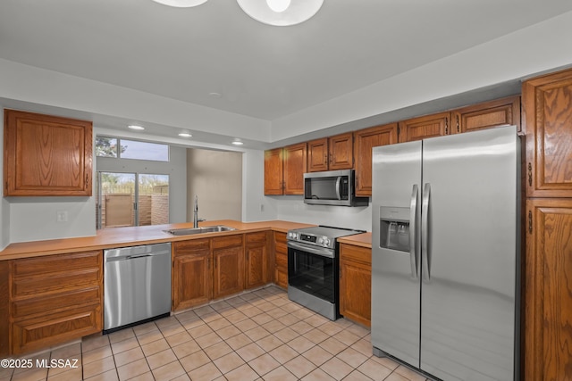 kitchen with sink, light tile patterned floors, and stainless steel appliances