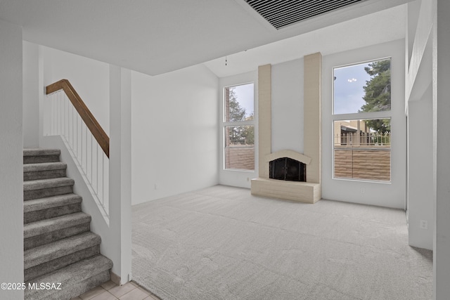 unfurnished living room featuring light tile patterned floors and a large fireplace