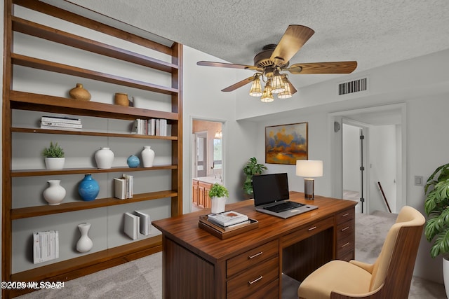 office area featuring ceiling fan, light colored carpet, built in features, and a textured ceiling