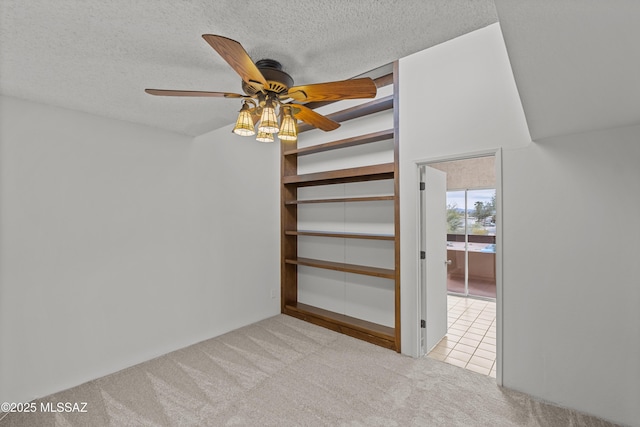 interior space with ceiling fan, light carpet, and a textured ceiling