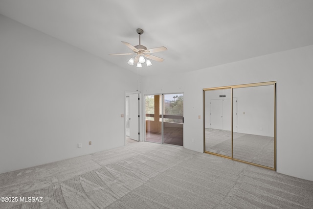 unfurnished bedroom with ceiling fan, light colored carpet, and lofted ceiling