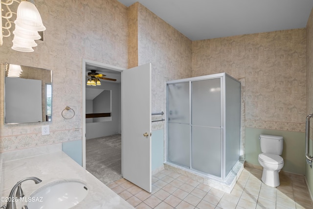 bathroom featuring tile patterned floors, walk in shower, vanity, ceiling fan, and toilet