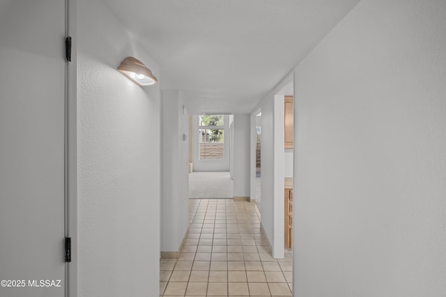 hall with light tile patterned floors