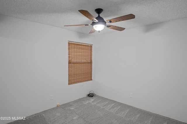 empty room with ceiling fan, carpet floors, and a textured ceiling