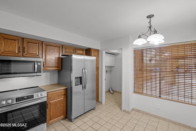 kitchen featuring decorative light fixtures, a notable chandelier, and appliances with stainless steel finishes