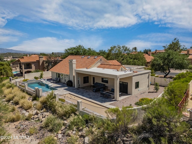 back of property featuring a fenced in pool and a patio area