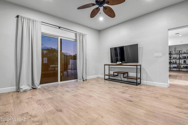 living room with ceiling fan and light hardwood / wood-style flooring