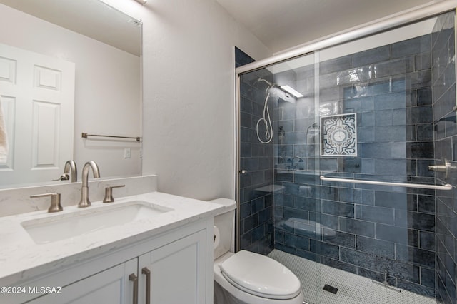 bathroom featuring vanity, toilet, and a shower with shower door