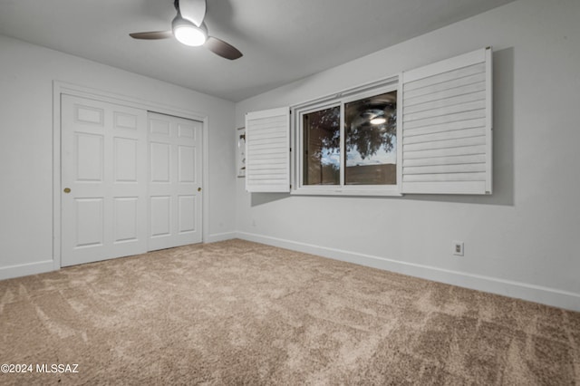 unfurnished bedroom with carpet, ceiling fan, and a closet