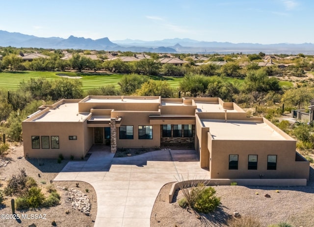 view of front of property featuring stucco siding, a mountain view, and a patio