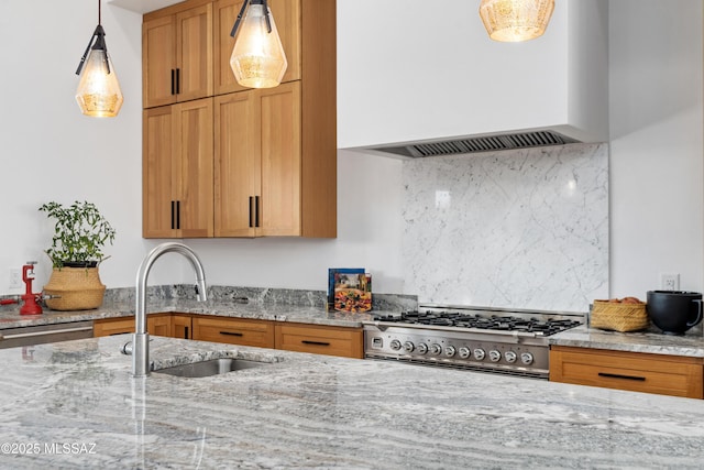 kitchen with custom exhaust hood, a sink, appliances with stainless steel finishes, decorative light fixtures, and light stone countertops