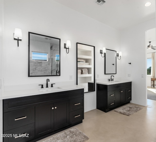 full bathroom featuring a walk in shower, two vanities, concrete floors, and a ceiling fan