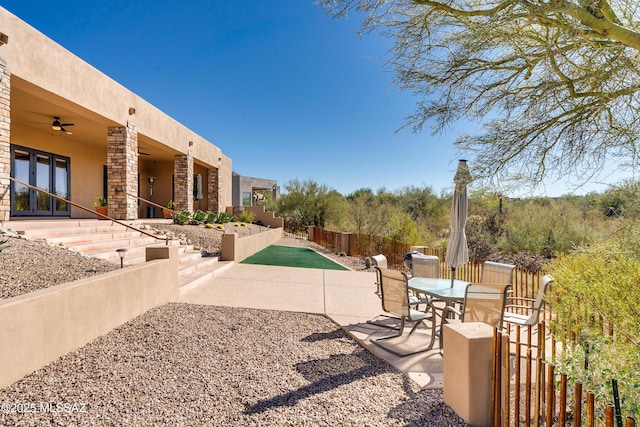 view of patio with ceiling fan and fence