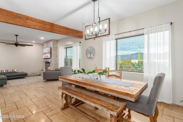 dining space with a fireplace, beamed ceiling, and ceiling fan with notable chandelier